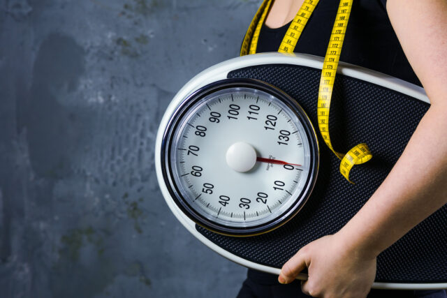 Diet and weight - young woman with a scale,