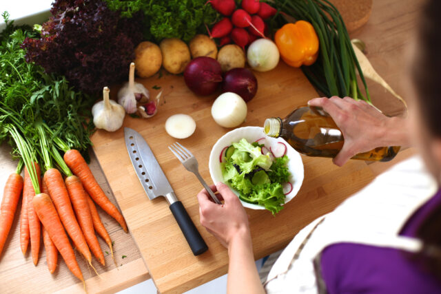 Young woman cutting vegetables in the kitchen .